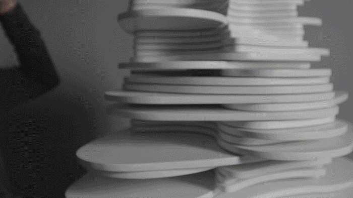 Video of a woman moving her hand up and down, which releases sonic chords and light effects from the center of the sculpture