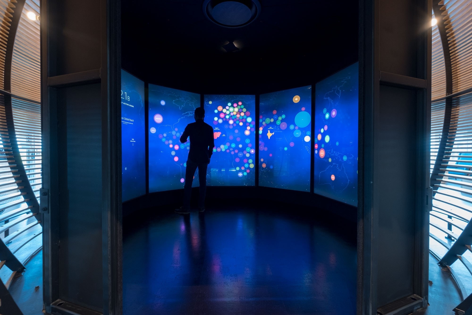 Person standing inside a wooden globe with an abstract map view