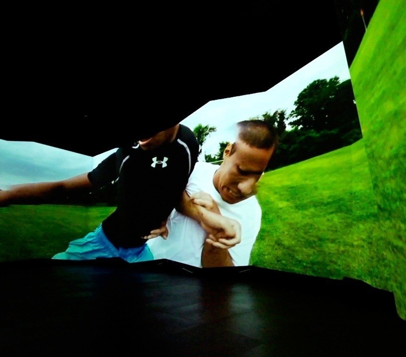 An angular and dynamic ceiling-to-floor screen that displays two athletes playing a team sport