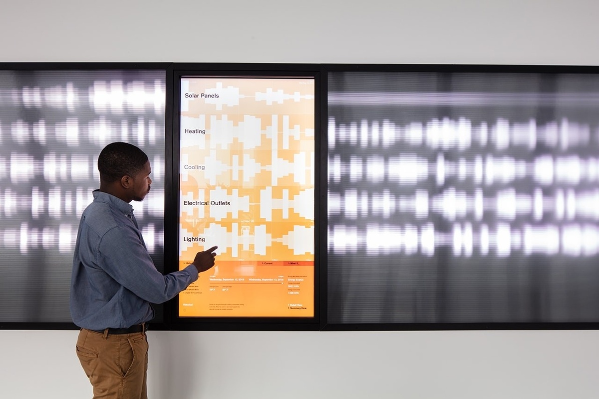 Closeup of man touching orange screen with pulsing white lines coming from sides of screen