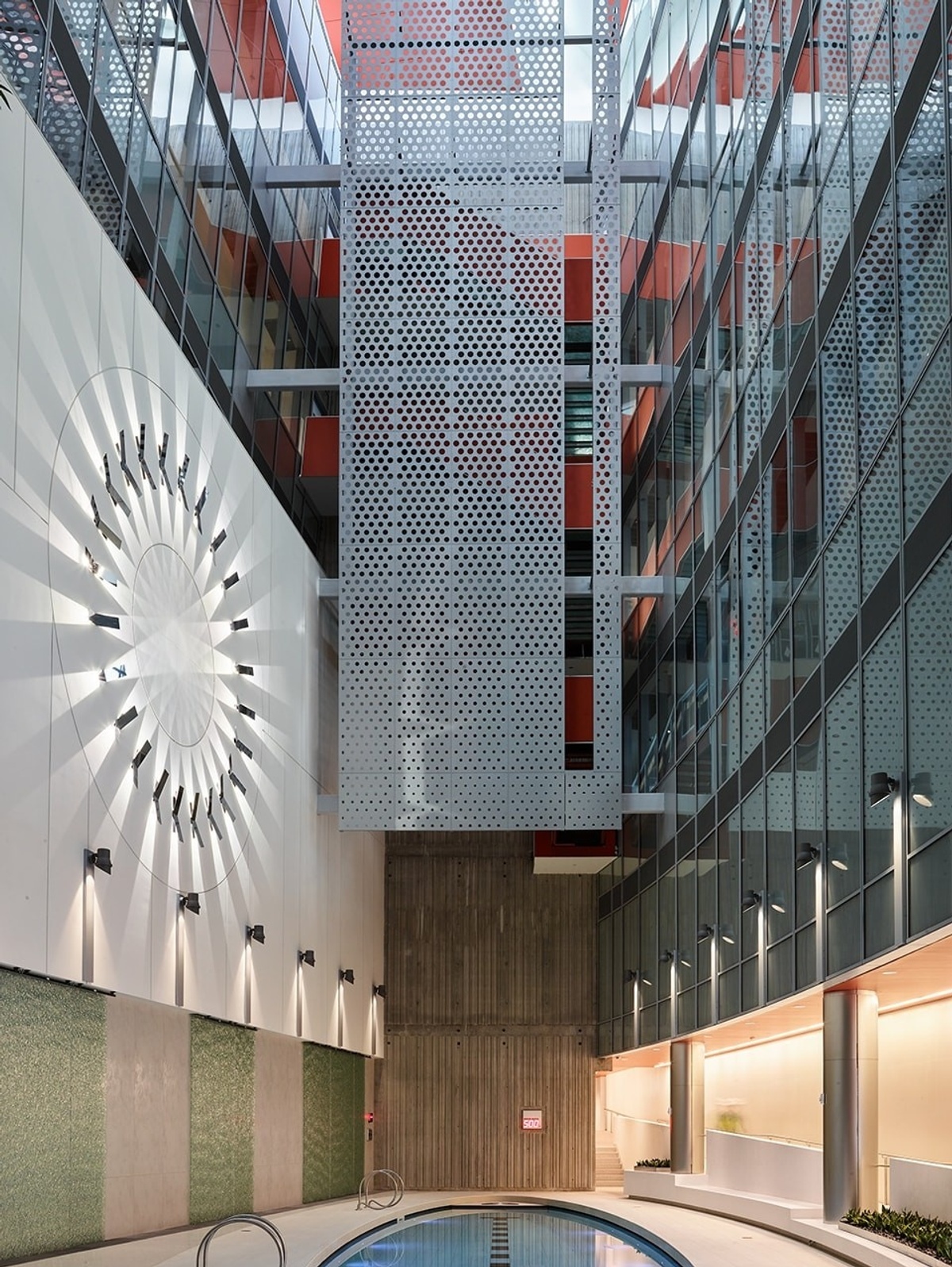 Interior photograph of room with large illuminated circular sculpture on wall