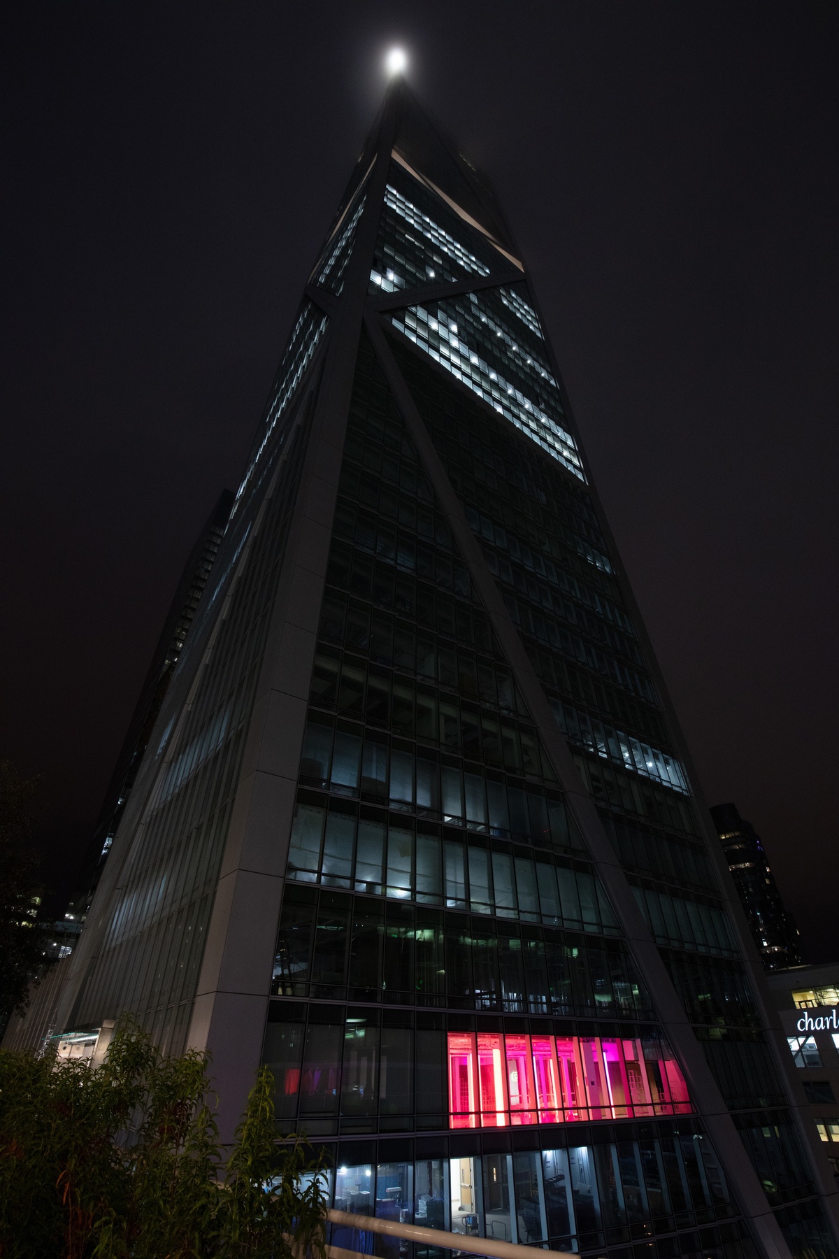 Tall building with room illuminated in pink light