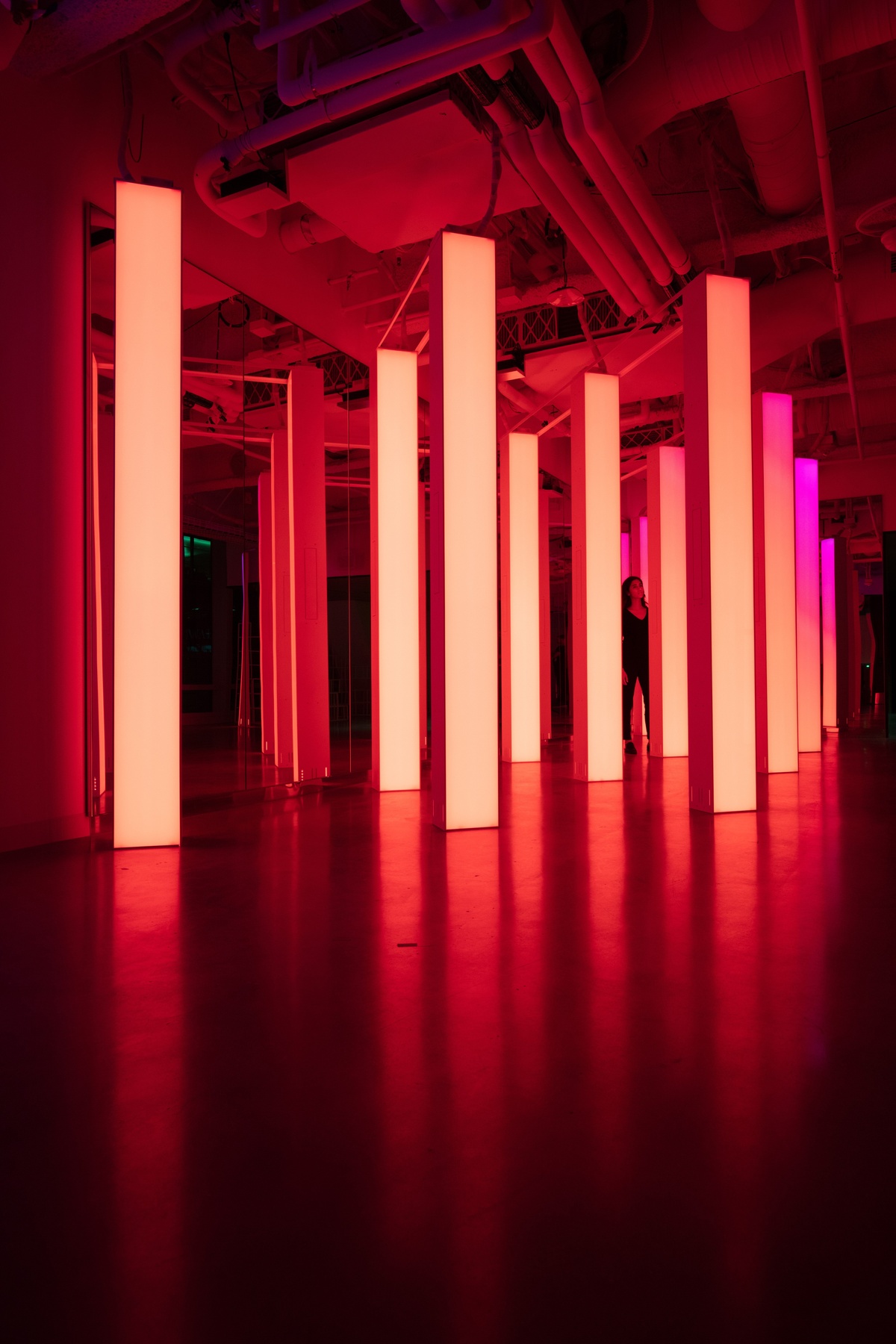 Young woman standing behind pillars with orange gradient