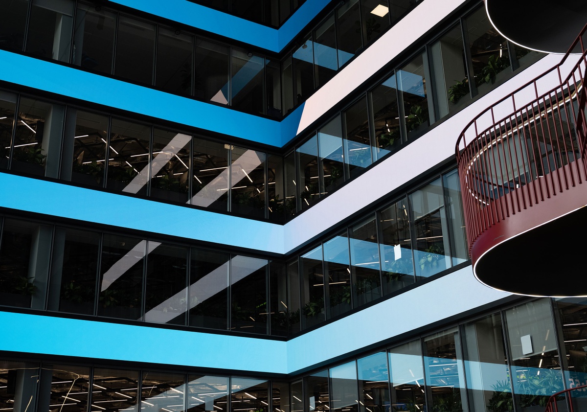 Four LED screens wrapping the interior of the atrium with blue and white gradients