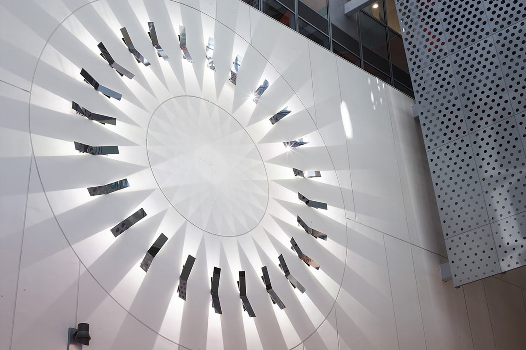 Angle view of Illuminated round metal sculpture on wall